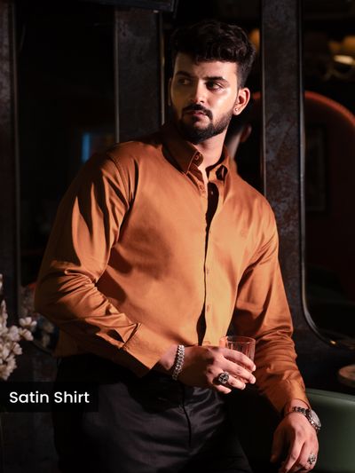 Rust Orange Satin Shirt Man in an orange " Premium satin shirts " holding a glass, posing indoors.